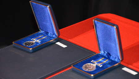 Photo of two Long Service Medals on a red table cloth.