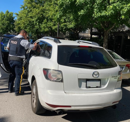 Richmond RCMP officer conducting vehicle check on white car