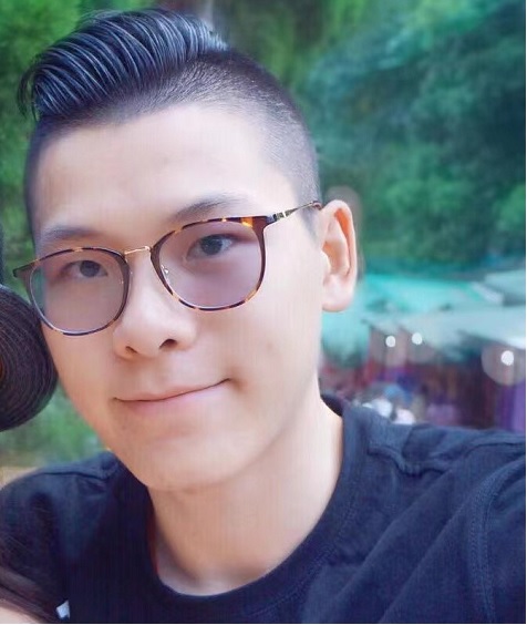 Photo prise à l’extérieur de Jiexiong Xu qui porte des lunettes et un tee-shirt.