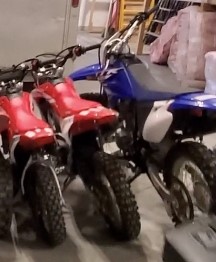 Three dirt-bikes, two red, one blue 
