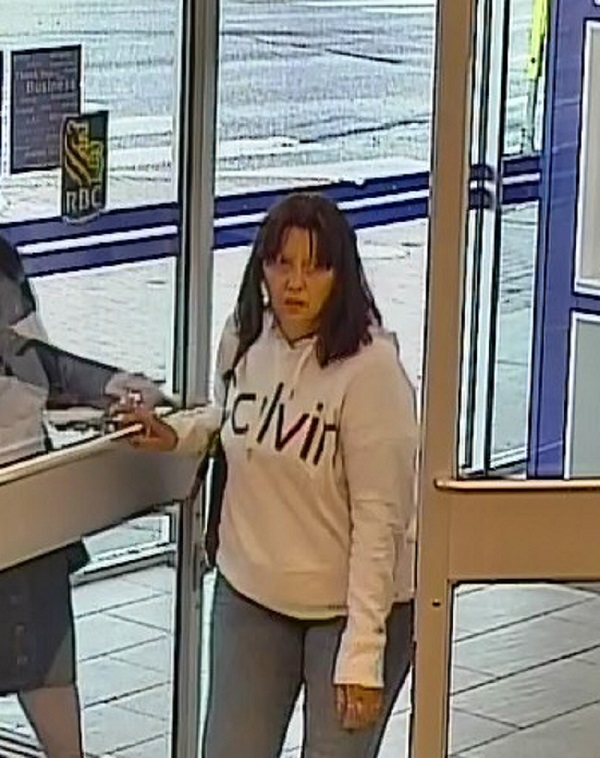 Woman suspect with shoulder length dark brown hair, wearing a white <q>calvin</q> hoodie