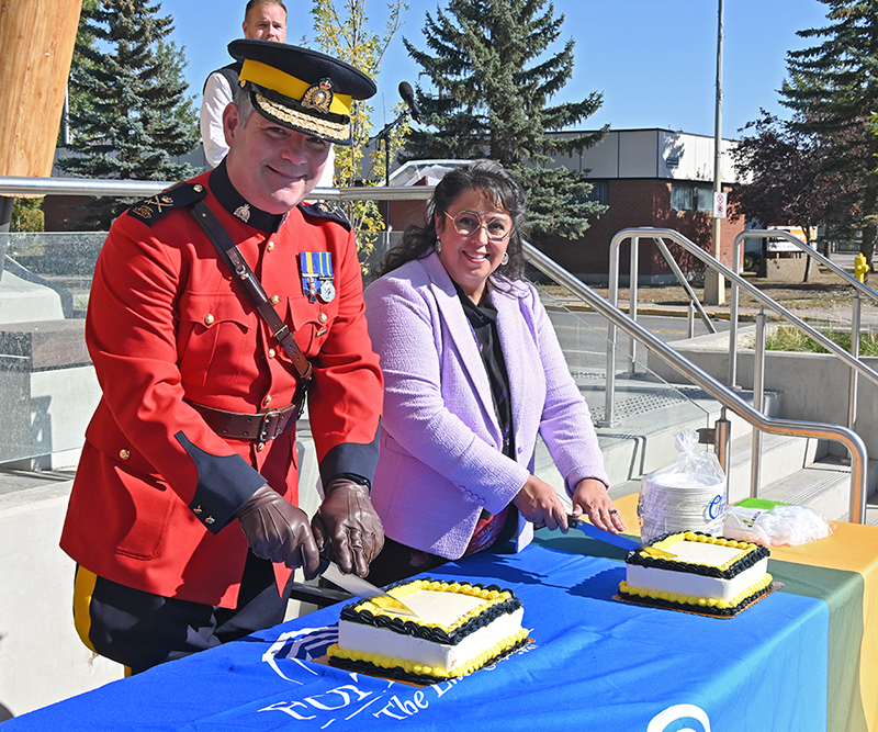 Deputy Commissioner Dwayne McDonald and Mayor Lilia Hansen cut the cake.