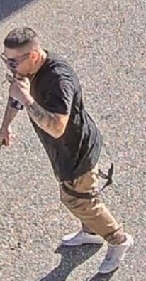 Photo du premier suspect vêtu d’un t shirt noir, d’un pantalon beige et de chaussures blanches.
