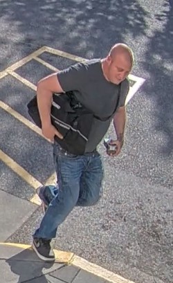 Photo du deuxième suspect vêtu d’un t shirt gris, d’un jean bleu et de souliers de course noirs/blancs et portant un sac noir.